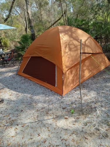 an orange tent is sitting in the dirt at Skyacres in Chiefland