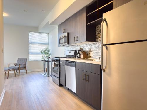 a kitchen with a stainless steel refrigerator and a table at Studio Suite - 5 Min Walk to Crypto Arena and Convention Center in Los Angeles
