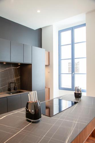 - une cuisine avec un comptoir en verre dans une pièce dans l'établissement Douceur Nîmoise, à Nîmes