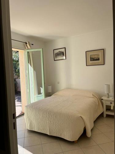 une chambre avec un lit et une porte coulissante en verre dans l'établissement Villa avec piscine privative et vue imprenable sur le golf de Saint-Florent à 300 m de la plage, à Saint-Florent