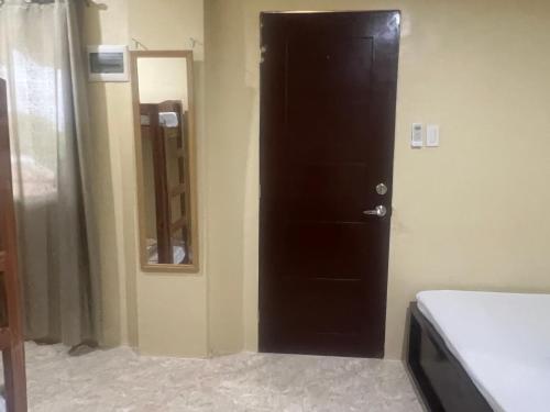 a black door in a room with a mirror at Seamed Guest House - Family Room A in Pooc