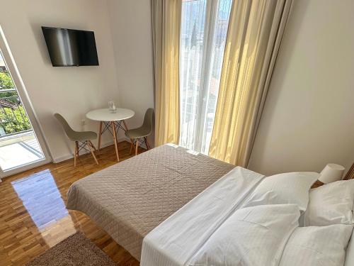 Un dormitorio con una cama y una mesa y una ventana. en Sea Star AP4, en Bar