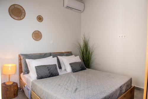 a bedroom with a bed with white and gray pillows at Antonakis Villa Rhodes Private Pool & Jacuzzi Retreat in Kremasti
