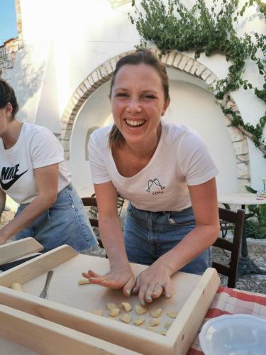 a woman standing next to a cutting board with food at Masseria Del Crocifisso in Polignano a Mare
