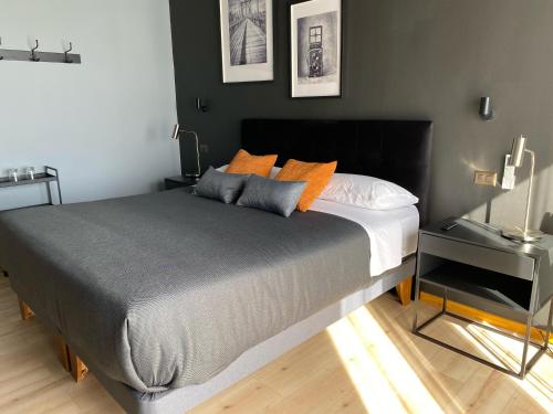 a bedroom with a large bed with orange pillows at Hotel Boutique 501 in Los Ángeles