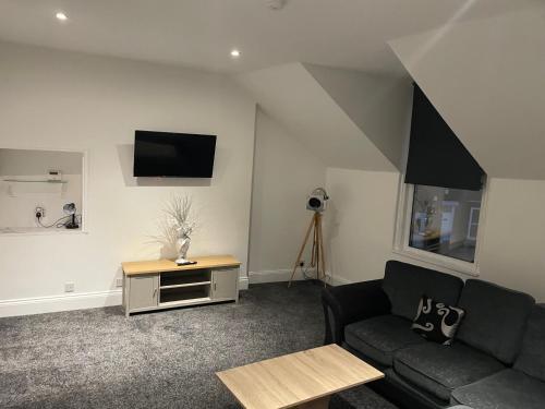 a living room with a couch and a tv on the wall at Roseville in Sunderland