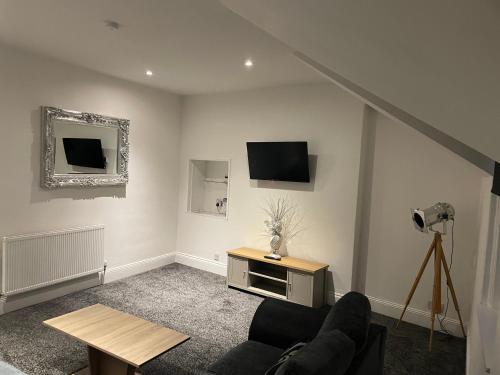 a living room with a couch and a tv on the wall at Roseville in Sunderland