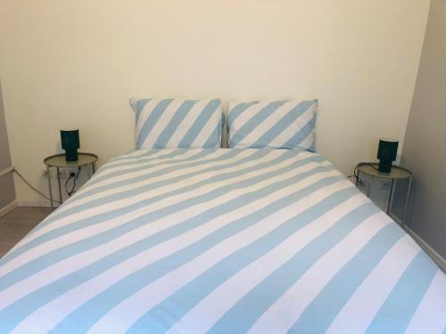 a blue and white bed in a room with two tables at Superbe T3 calme proche de Lille - La Madeleine in La Madeleine