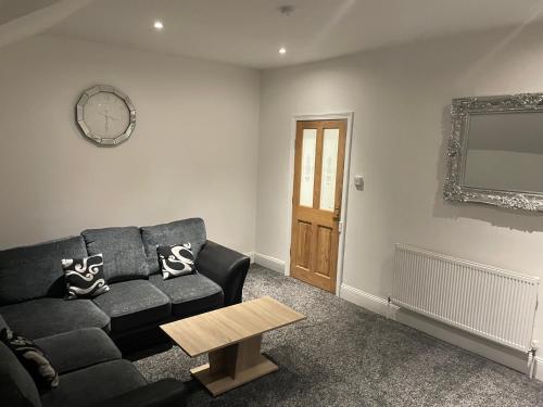 a living room with a black couch and a table at Roseville in Sunderland