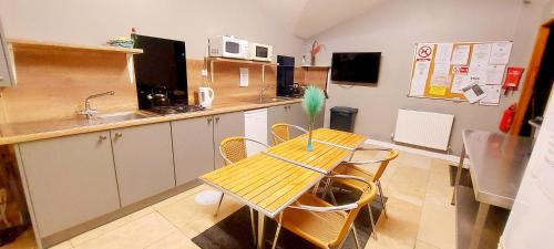 ドルゲラウにあるBunkhouse Accommodation in the Heart of Snowdoniaの小さなキッチン(木製のテーブルと椅子付)