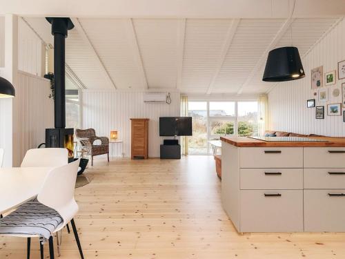 a kitchen with white cabinets and a table and chairs at Cozy Coastal Retreat - By Traum Ferienwohnungen in Hjørring