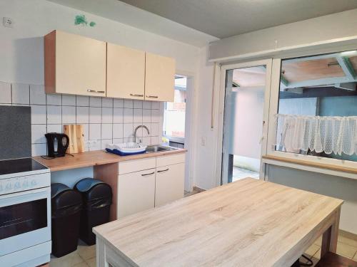a kitchen with white cabinets and a wooden table at Gäste Unterkunft 2 in Mönchengladbach