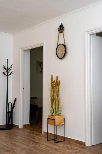 a room with a clock on a white wall at Tiszavirág Apartman Màrtèly in Mártély