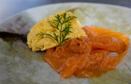 a plate of food with salmon and a garnishment at Eddrachilles Hotel in Scourie