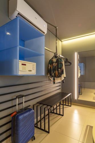 a room with a bench and a blue suitcase at Intercity Salvador in Salvador