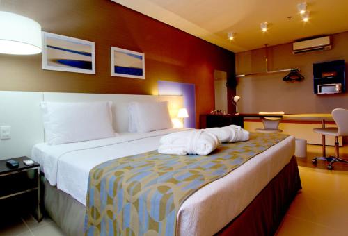 a hotel room with a bed with a towel on it at Intercity Salvador in Salvador