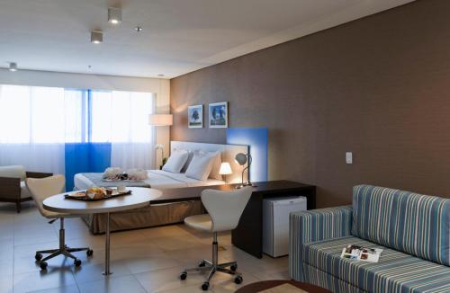 a hotel room with a bed and a table and chairs at Intercity Salvador in Salvador