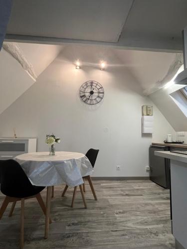 une salle à manger avec une table et une horloge au mur dans l'établissement Modern and bright studio, à Bourges