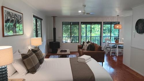 a bedroom with a bed and a living room at The Cottages On Mount Tamborine in Mount Tamborine