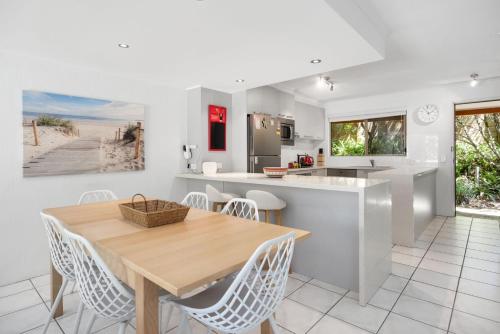 a kitchen and dining room with a wooden table and chairs at Parkside on Plover Street in Peregian Beach
