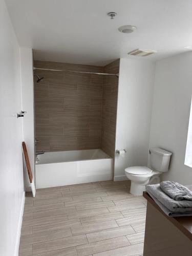 a bathroom with a bath tub and a toilet at Modern Unit Near Glendale Galleria and Walk to Shopping & Dining! in Glendale