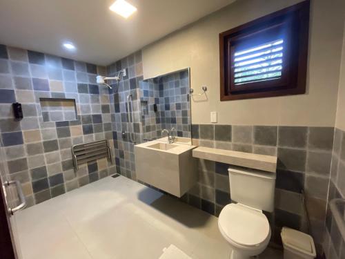 a bathroom with a toilet and a sink and a shower at Pousada Monteflor Guaramiranga-CE in Guaramiranga