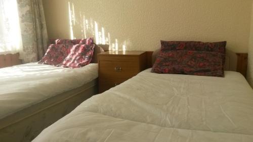 a bedroom with two beds with pillows on them at Lovely Chalet 15, Seadell Park in Hemsby