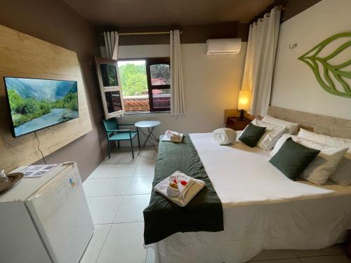 a hotel room with a large bed and a window at Pousada Monteflor Guaramiranga-CE in Guaramiranga