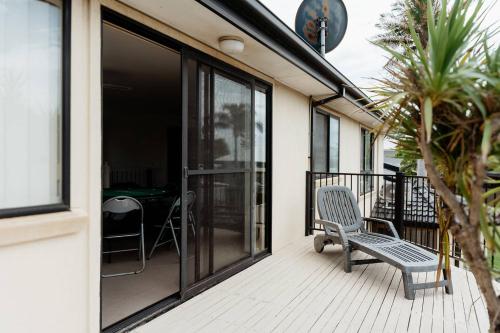 a chair sitting on a deck next to a house at Sunny Dayz Shellharbour in Barrack Point