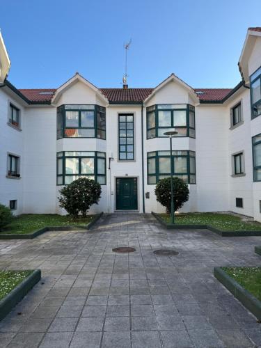a large white building with a green door at Lar de Cubeliños in Ribeira