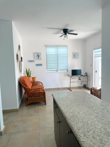 a kitchen with a ceiling fan and a living room at A few steps from Mar Bella Beach, Vega Baja! in Vega Baja