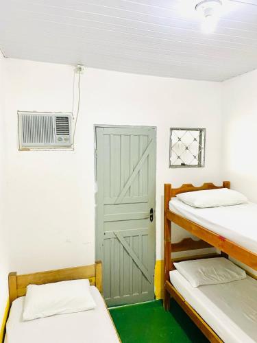 a room with two bunk beds and a door at Pousada Vila Rica in Bonito