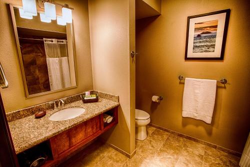 a bathroom with a sink and a toilet and a mirror at Lucky 7 Casino & Hotel (Howonquet Lodge) in Smith River