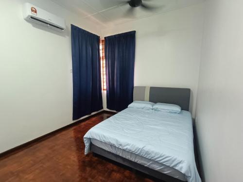 a small bedroom with a bed with blue curtains at Paradigm Mall-Skudai-Sutera-Johor Bahru-K&A Homestay-12 pax in Johor Bahru