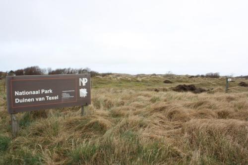a sign in the middle of a field at DuinHotel Texel in De Koog
