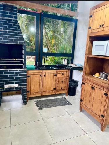 a kitchen with a sink and a large window at Quarto Recanto Monte Trigo in São Francisco do Sul