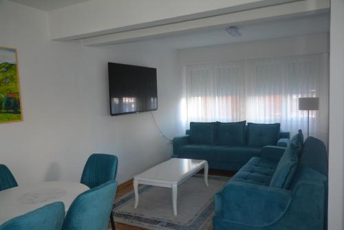a living room with a couch and chairs and a table at Turquoise Apartment in Novi Pazar