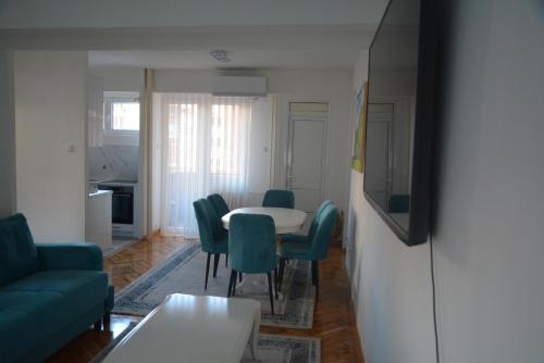 a living room with a table and chairs at Turquoise Apartment in Novi Pazar