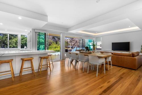 a kitchen and living room with a table and chairs at BEACH01- Mooloolaba Beachfront Apartment with Private Pool in Mooloolaba