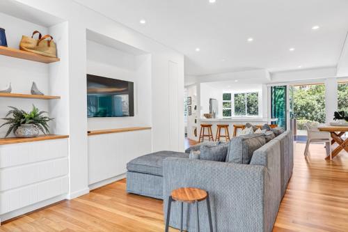 a living room with a gray couch and a table at BEACH01- Mooloolaba Beachfront Apartment with Private Pool in Mooloolaba