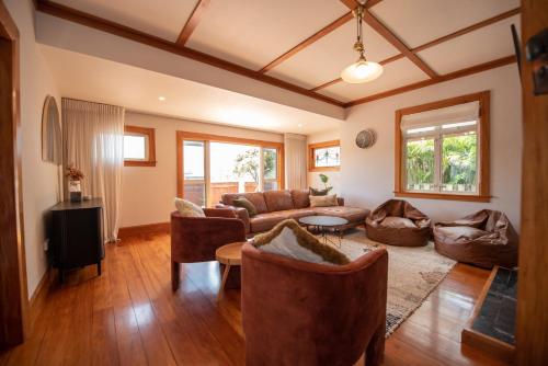 a living room with a couch and a table at Pohutukawa Tides - Walk to Beach, Large Fenced Section in New Plymouth