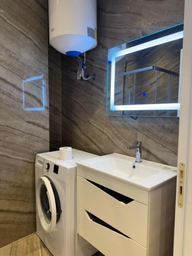a bathroom with a washing machine and a sink at Deluxe Apartments Shengjin in Shëngjin