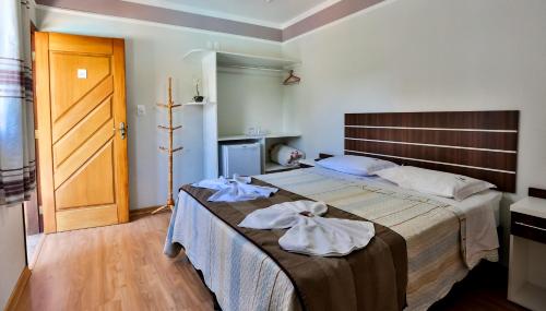 ein Schlafzimmer mit einem großen Bett mit Handtüchern darauf in der Unterkunft Pousada Igarapé in Socorro