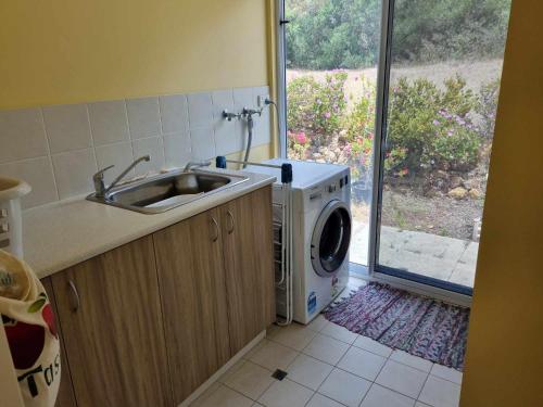 a kitchen with a sink and a washing machine at Lavender Cottage at Nannup Lavender Farm in Nannup