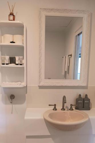 a bathroom with a sink and a mirror at The Cottages On Mount Tamborine in Mount Tamborine