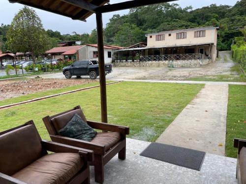 a couch on a porch with a view of a building at Pousada Monteflor Guaramiranga-CE in Guaramiranga