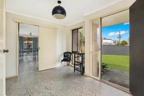 an open hallway with a dining room with a table and glass doors at NAROO7- PRIME, CENTRE OF MOOLOOLABA LOCATION in Mooloolaba