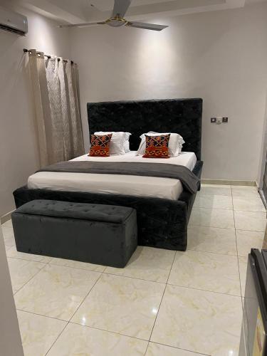 a bedroom with a large bed with a black headboard at Vickkesnat Luxury Homes in Kasoa