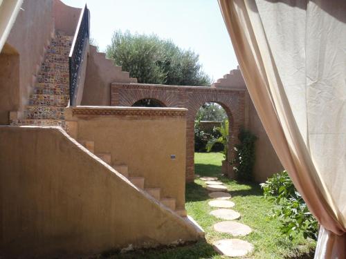 an entrance to a house with stairs and an arch at DAR TITRIT Charming house with garden and pool in Akhatar
