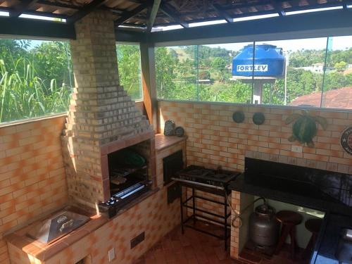 a brick oven in a kitchen with a window at Recanto Santa Helena Iriri Santa Helena in Anchieta
